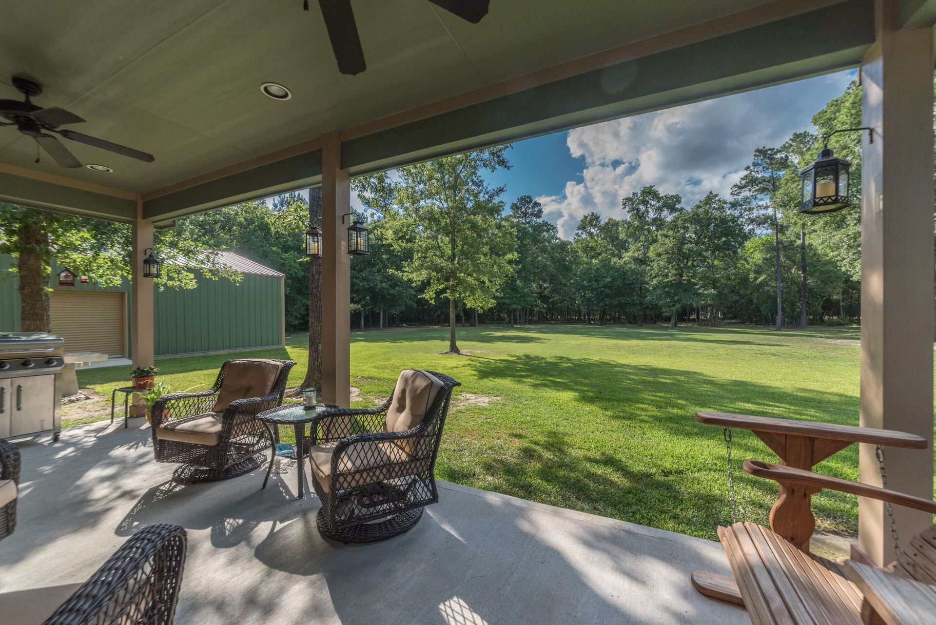 Covered porch overlooking the wooded yard at White Oak Trails